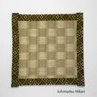 Square tatami coaster with a green and beige ichimatsu checkered pattern in the centre and a gold and olive patterned fabric border.