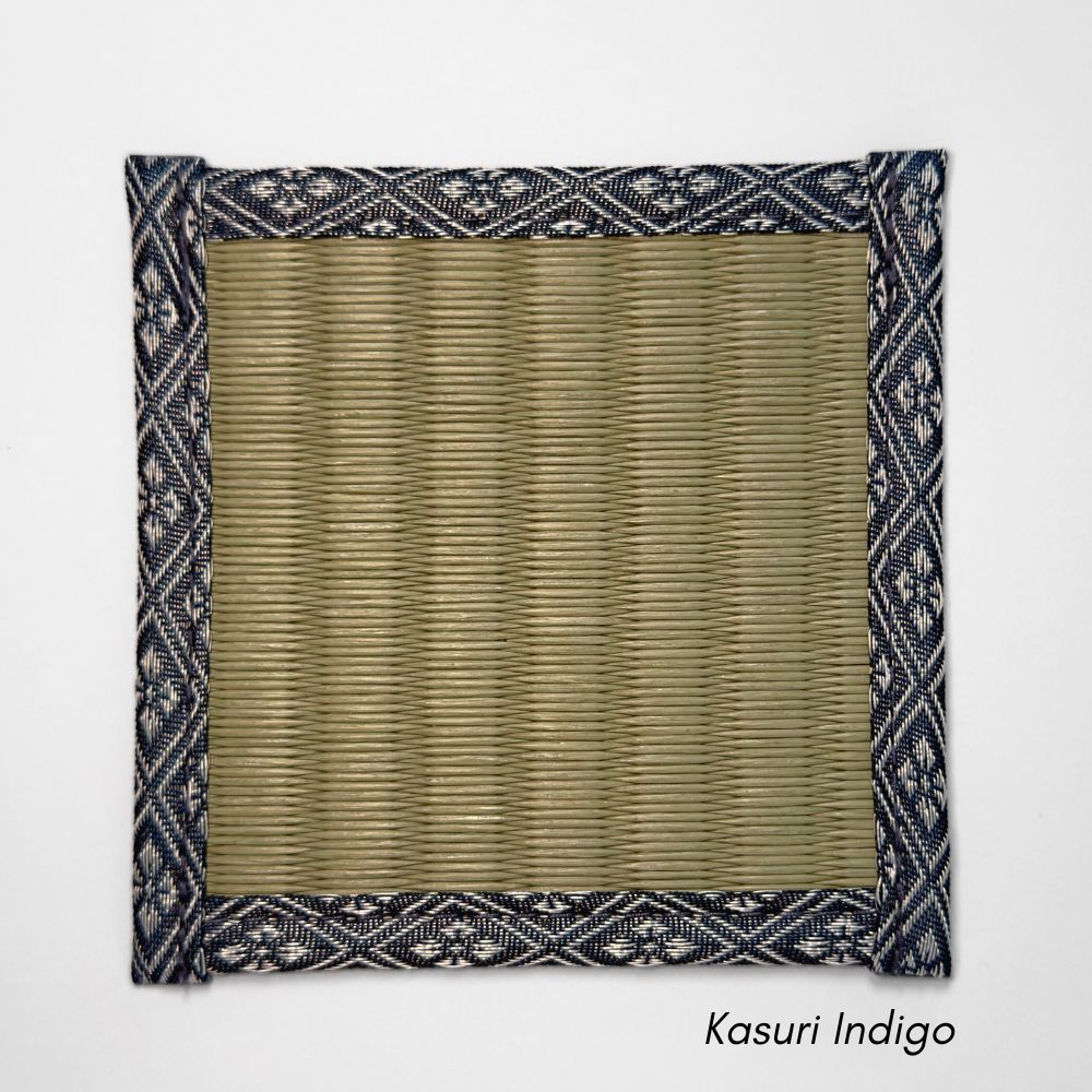 Square tatami coaster with a smooth olive igusa centre and a navy and white kasuri style geometric fabric border.