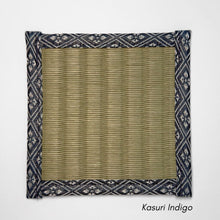 Square tatami coaster with a smooth olive igusa centre and a navy and white kasuri style geometric fabric border.