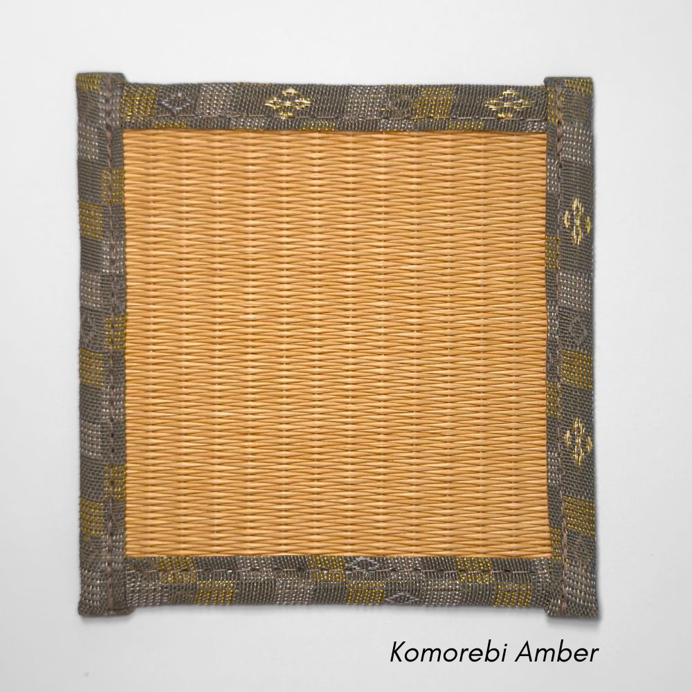 Square tatami coaster with a warm amber coloured igusa centre and a muted grey and olive patterned fabric border.
