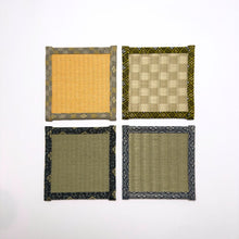 Top down view of four square tatami coasters arranged in a grid, each with a different woven centre and decorative fabric border.