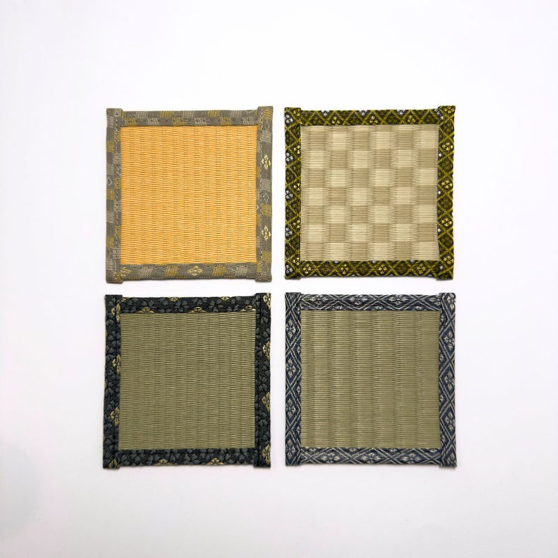 Top down view of four square tatami coasters arranged in a grid, each with a different woven centre and decorative fabric border.